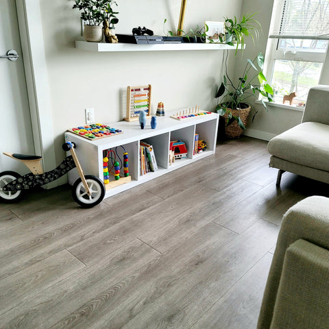 A baby sized furniture with montessori toys and activities set up in the living room of a home 