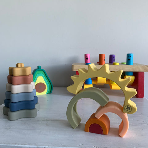 silicone and wooden stacking toys for babies and toddlers on a white table