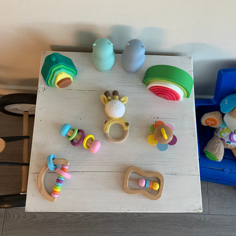 Mwooden and silicone montessori baby toys on a baby sized furniture at home
