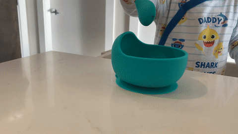 baby using his set of suction base silicone baby bowl