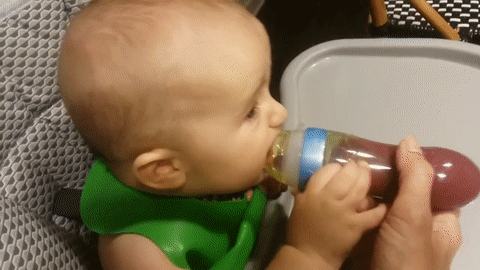 baby eating mushed food from a silicone squeeze self feeding baby spoon