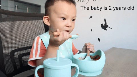 bébé mange dans sa gamelle en silicone avec ventouse et cuillère