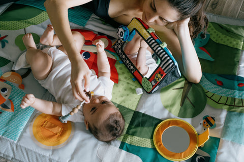 Mom playing with baby with different activities while baby has a pacifier holder