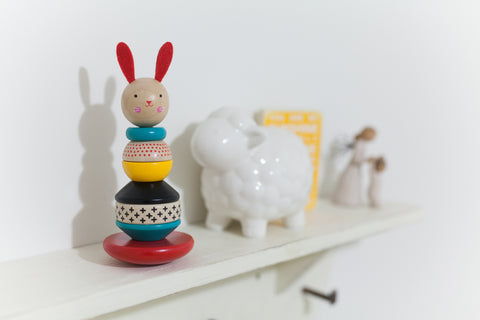 A wooden toy placed on a shelf on the wall in a room