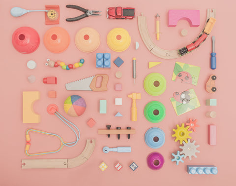 wooden toys and tools for kids on a pink background