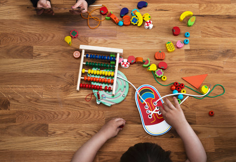Un enfant jouant avec des jouets en bois sur une table dans un cadre Montessori