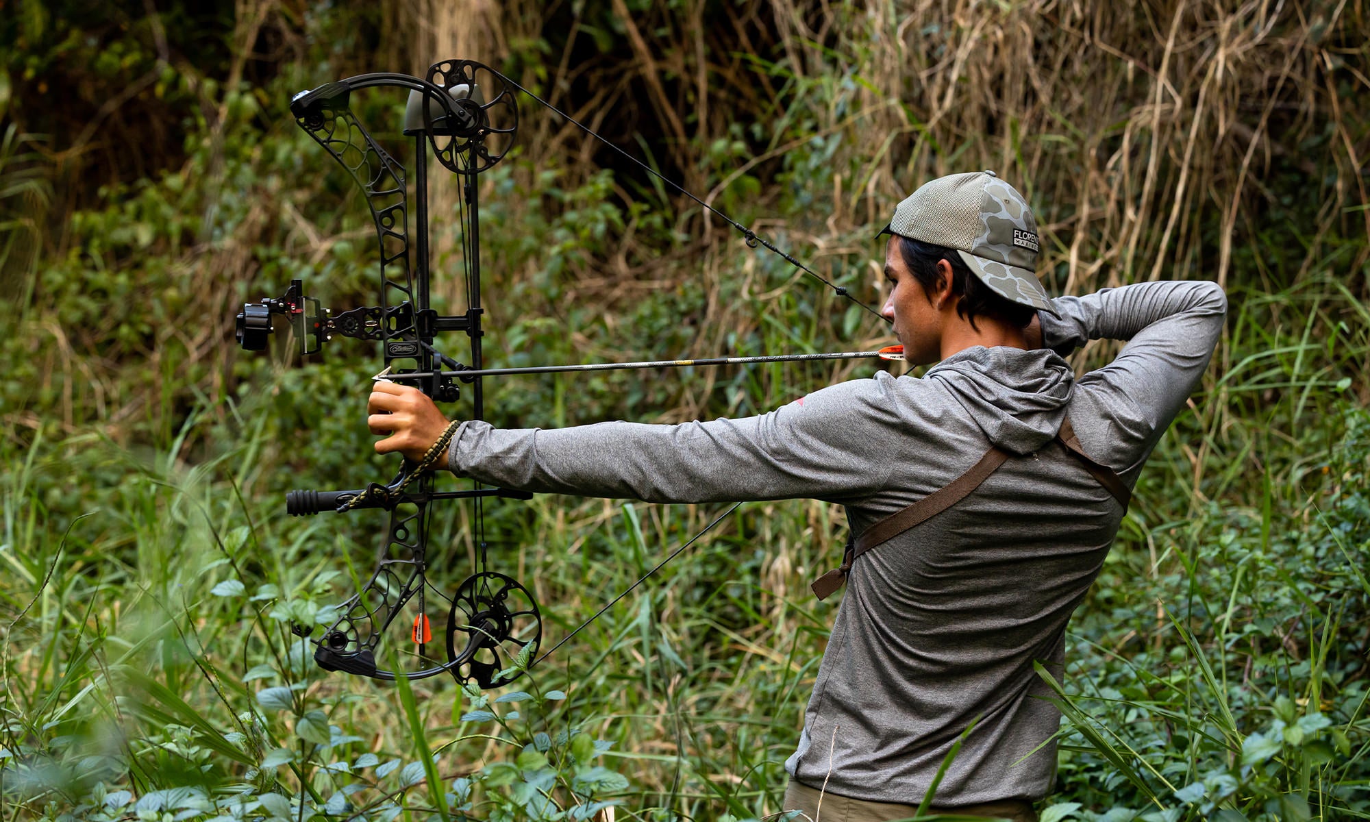 Maddix boar hunting in the jungle with a bow, wearing the Florence Adapt Sun Protection UPF