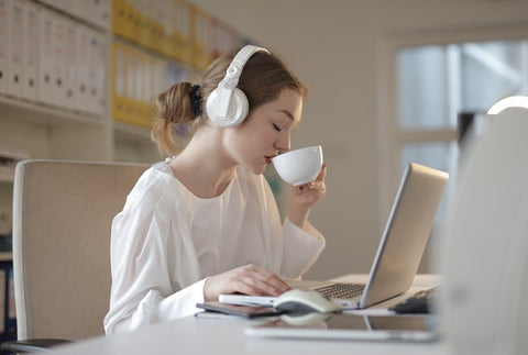 Mujer en ordenador bebiendo té ecológico