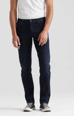 Unterkörper eines Mannes in Jeans und Sneakern