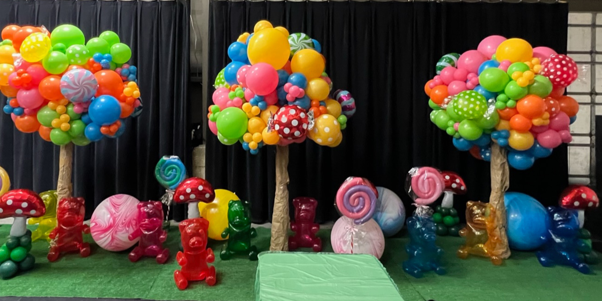 Balloon candy trees and jumbo balloon candies fill the venue for an incredible Willy Wonka themed Christmas Party in Utah.