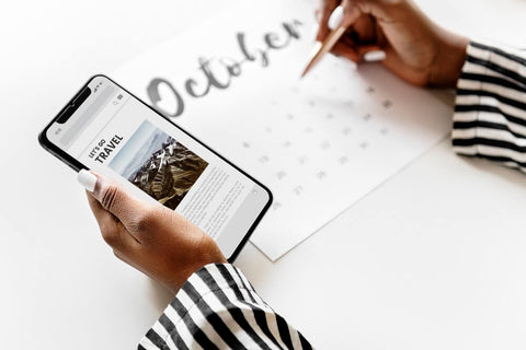 Picture of woman's hands scheduling an event from her phone to a calendar