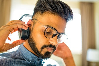 man with glasses and headset preparing to meditate