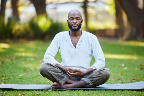 man meditating outdoors in lotus position