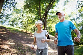 Older couple joggin together in the woods