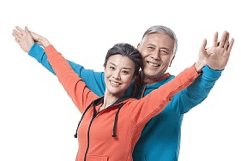 Healthy looking couple with arms raised celebrating their welness