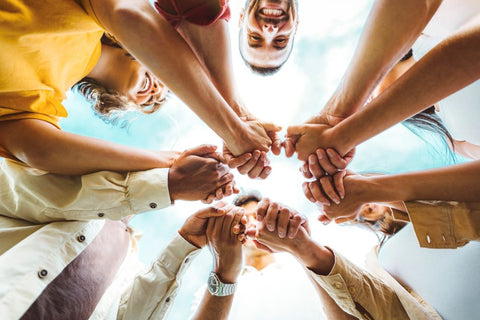 multi-ethnic group holding hands