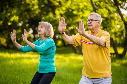 Middle aged couple doing tai chi outdoors