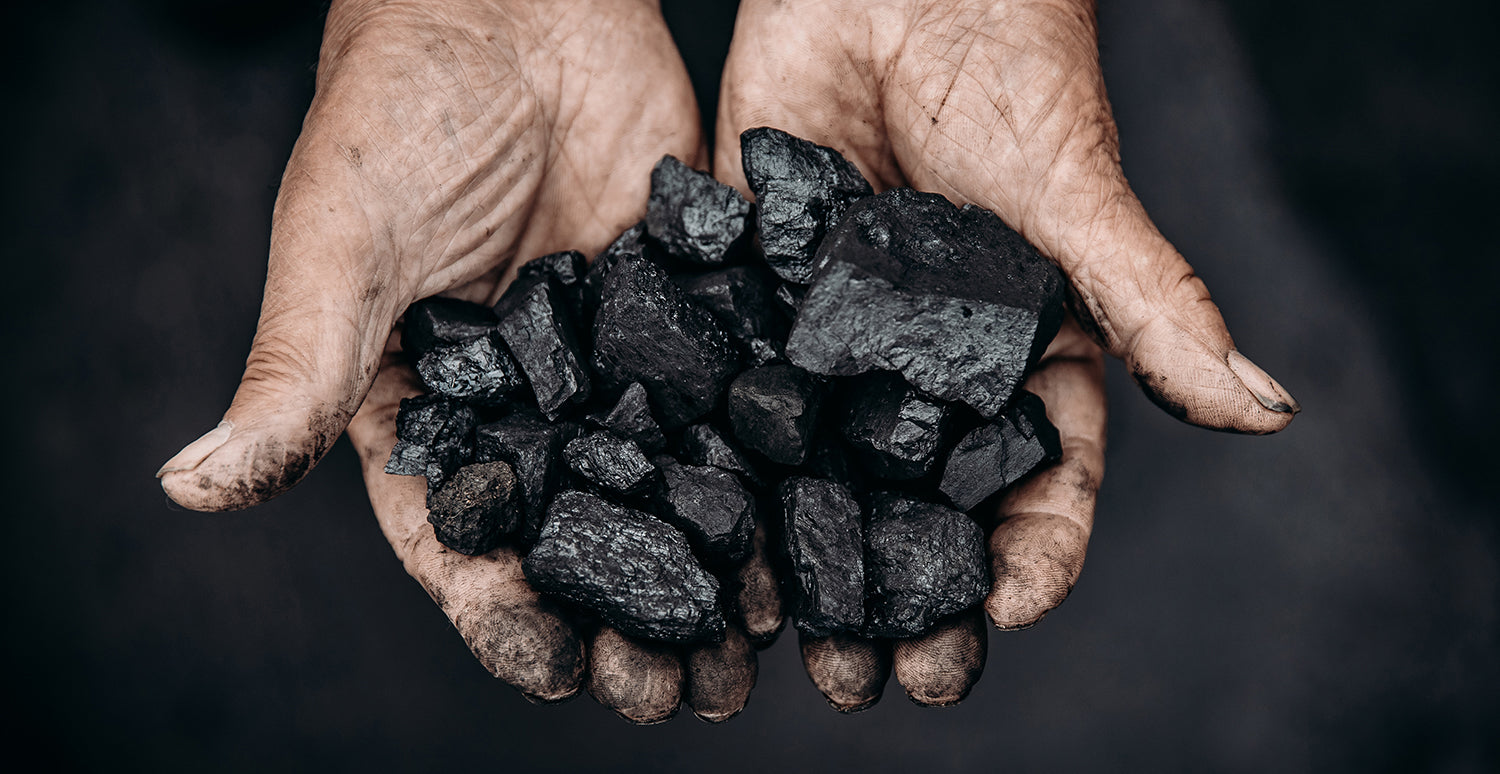 Person holding handful of coal