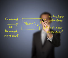 Business man writing a plan diagram on a transparent board