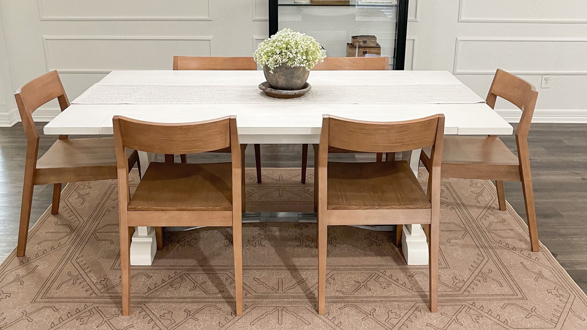 Solid wood dining chairs in pecan with white solid wood dining table and floral centerpiece