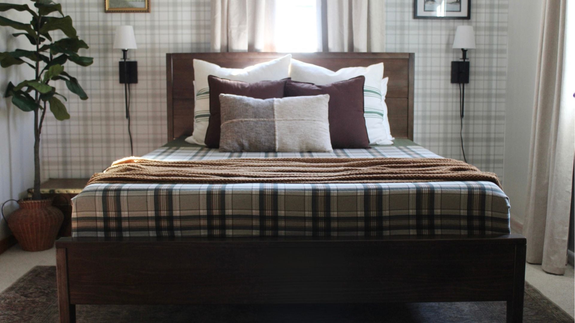 Queen-size wooden bed frame in walnut with plaid bedding, plaid wallpaper, and decor
