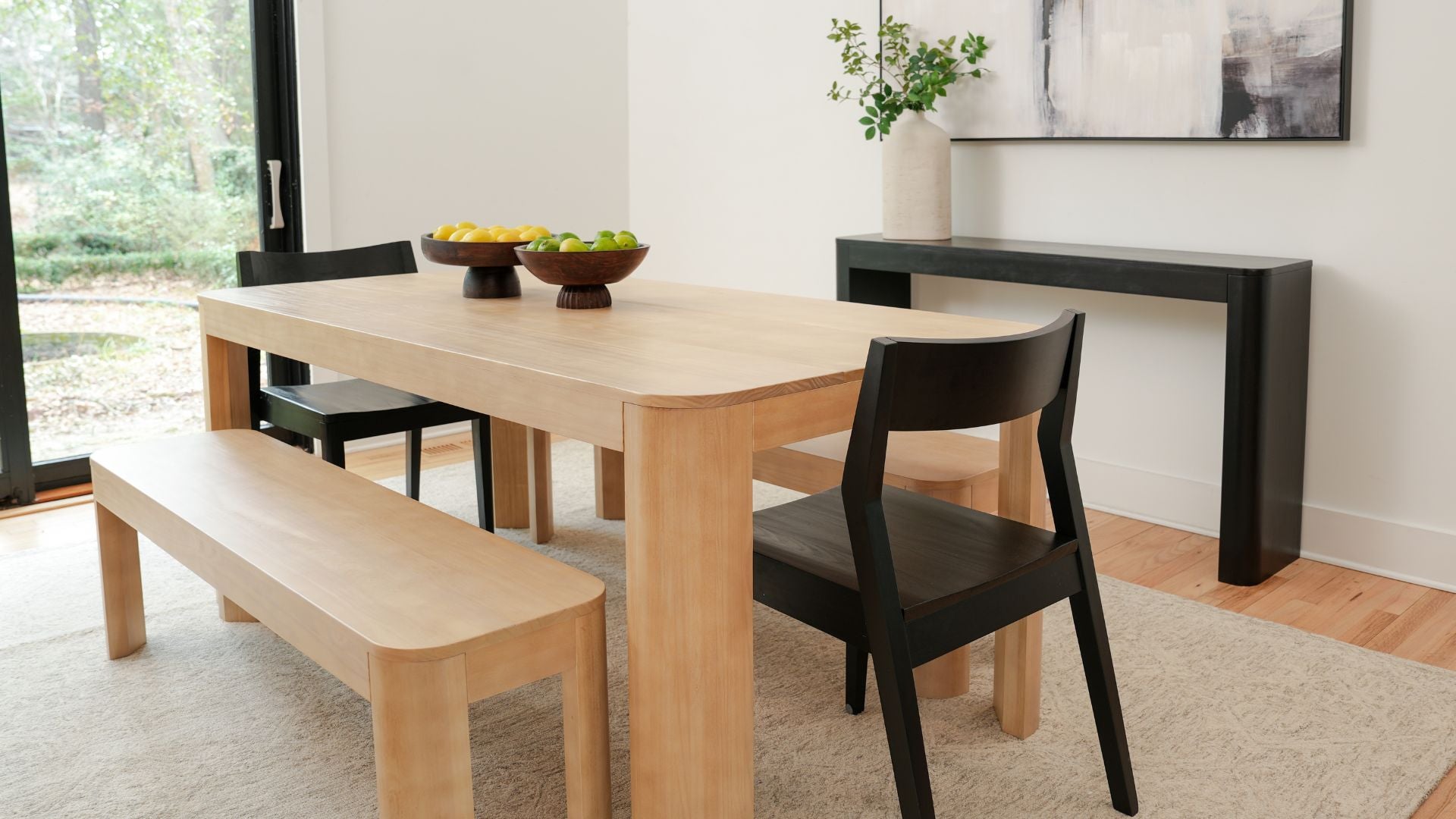 natural wood dining table and dining benches with black dining chairs and black console table