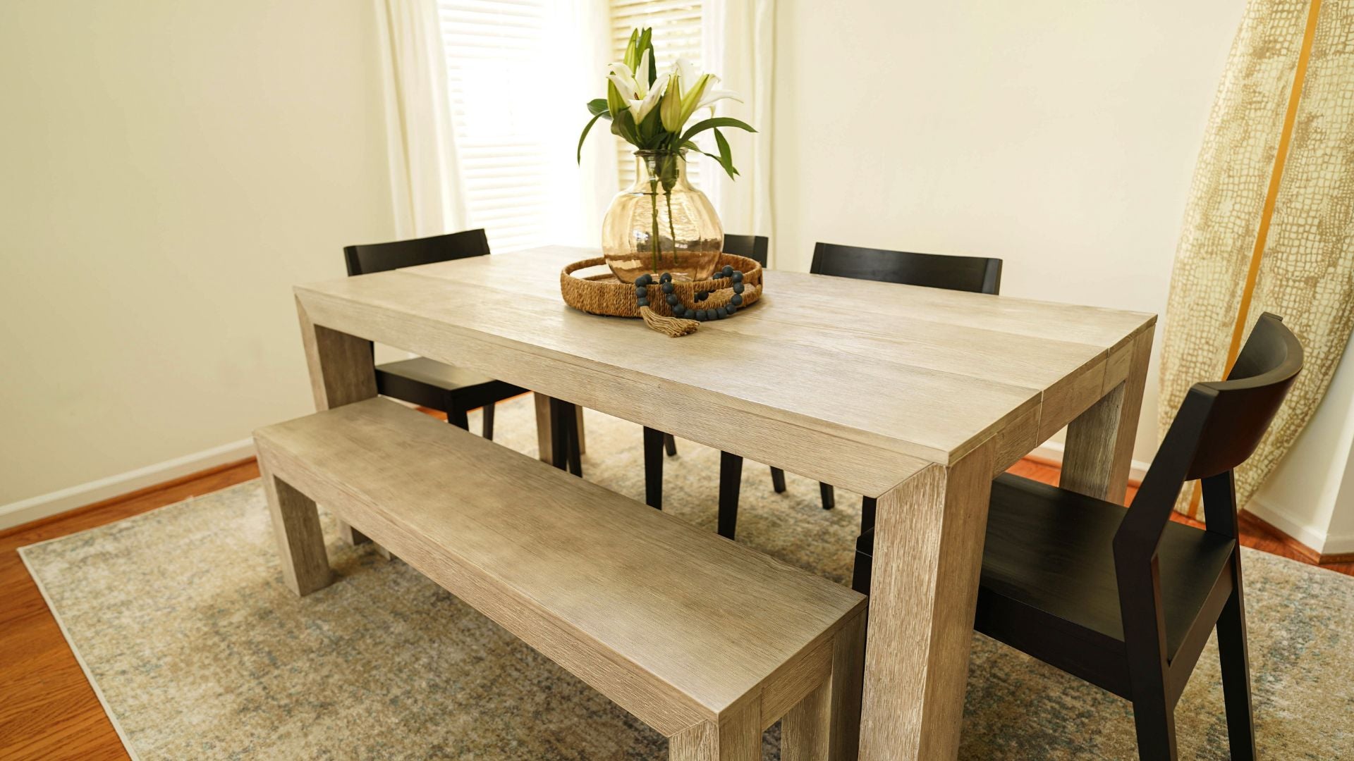 wooden table for dining with dining bench and black chairs