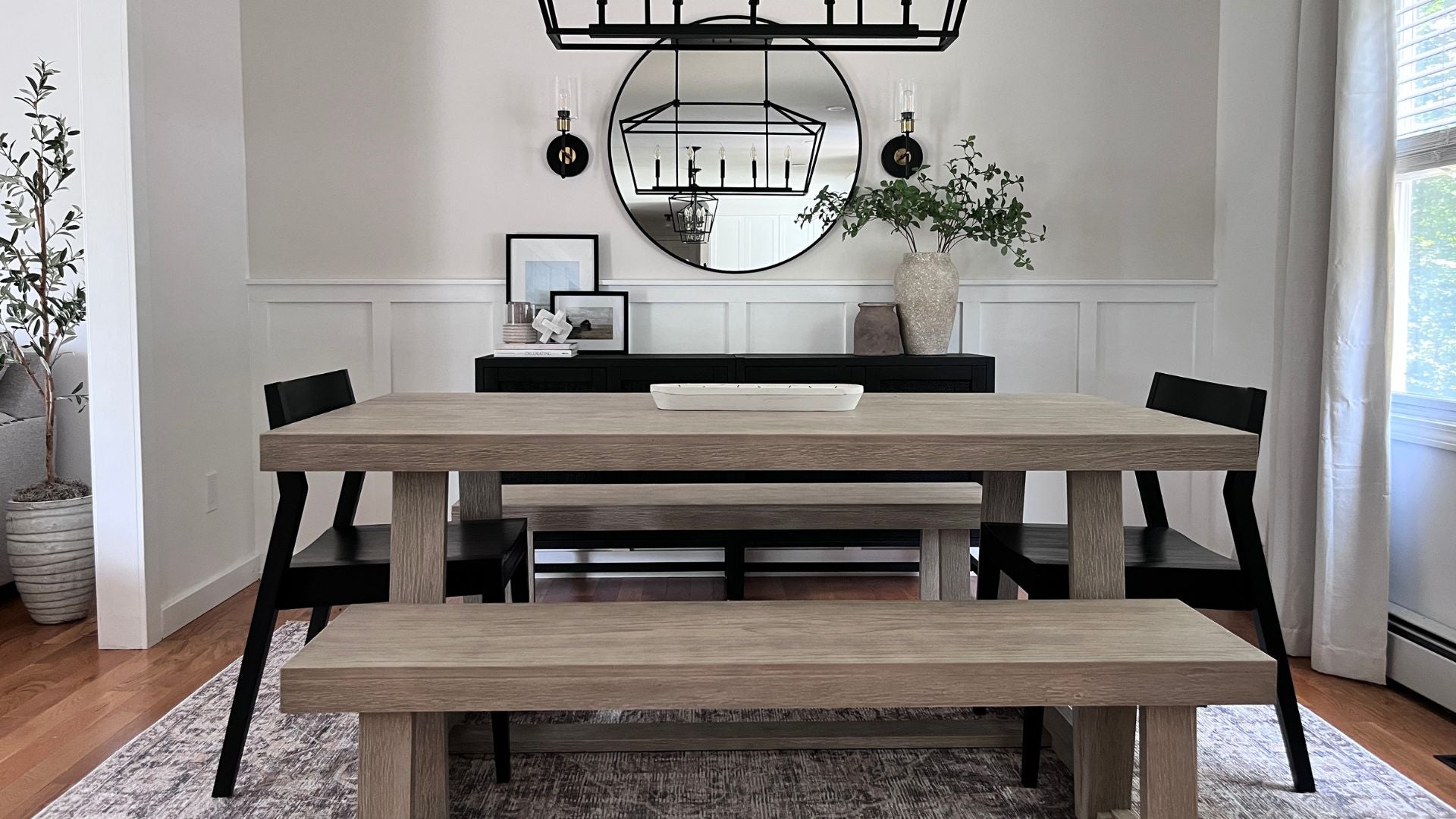 wooden dining table set with two dining benches and black dining chairs