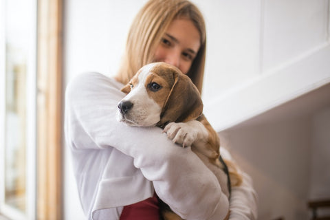 Blonde woman holding a dog in her arms