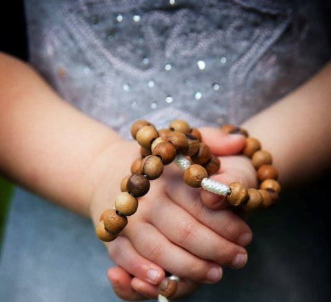 Sandalwood meditation bracelet being held in hand