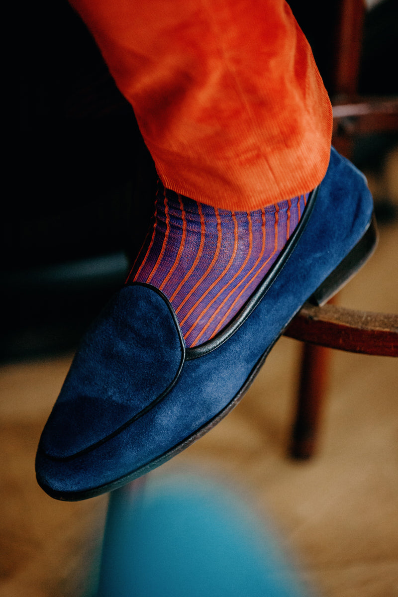 Chaussettes de couleur bleu roi avec des côtes contrastées oranges, en 100% fil d'Écosse. Modèle pour homme de mi-bas (chaussette montantes jusqu'au genoux) de la marque Mazarin. Chaussettes souples, douces et légères qui viennent mettre en valeur les pantalons de couleur bleu marine ou vives. Pointures : du 39 au 48