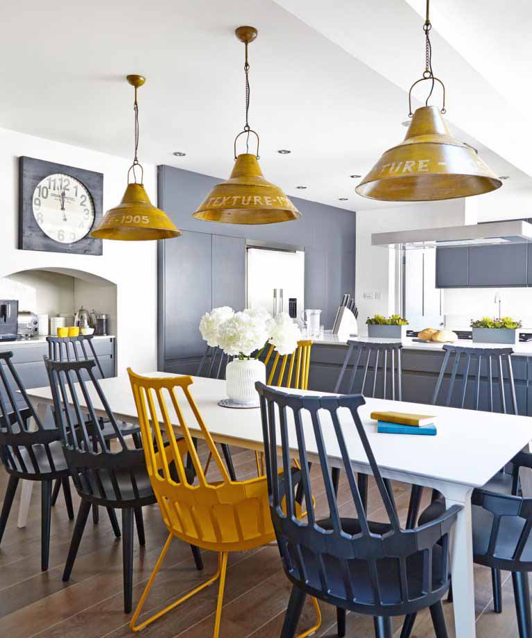 A long, white dining table with oker pendant lights in a spacious kitchen I ZenQ Designs