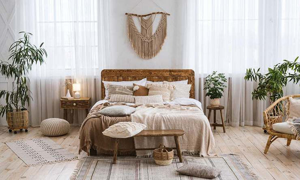 A wooden back of the bed and a macrame on a wooden stick above the bed