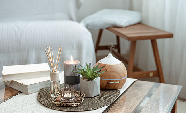 Composition with incense sticks, diffuser, candles and books on table - ZenQ Designs