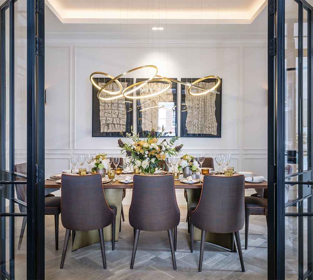 Modern golden spiral pendant lights above a luxurious dining table I ZenQ Designs