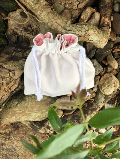 Small white canvas coloured precious pouch in tree stump