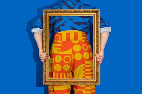model holding a frame over their bum which is clad in very brightly coloured pyjamas