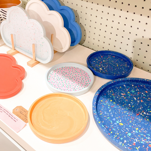 The Custard Tarts jesmonite trays in pink, blue and orange, some in cloud shape others circular