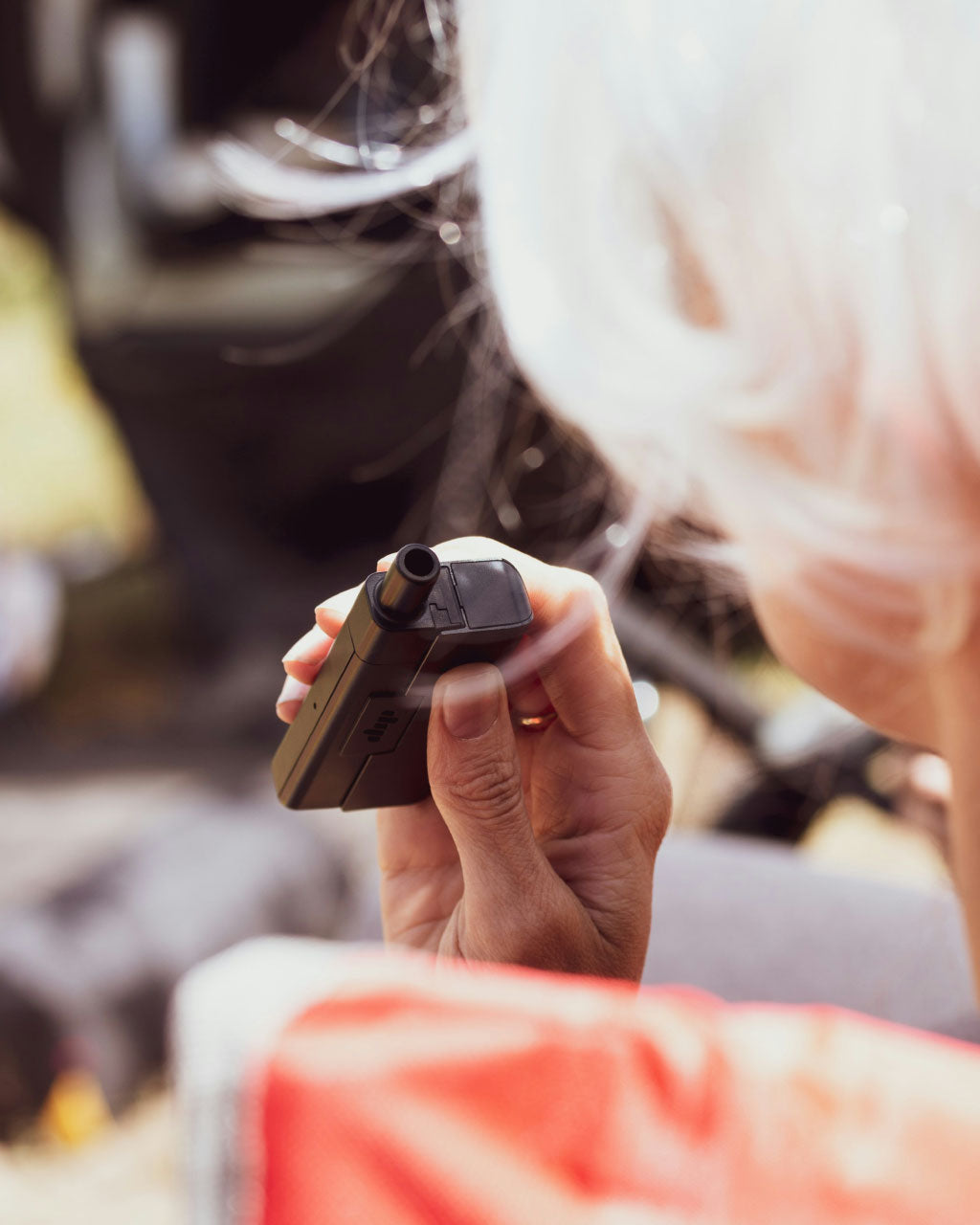 Image of a woman holding a vape device.