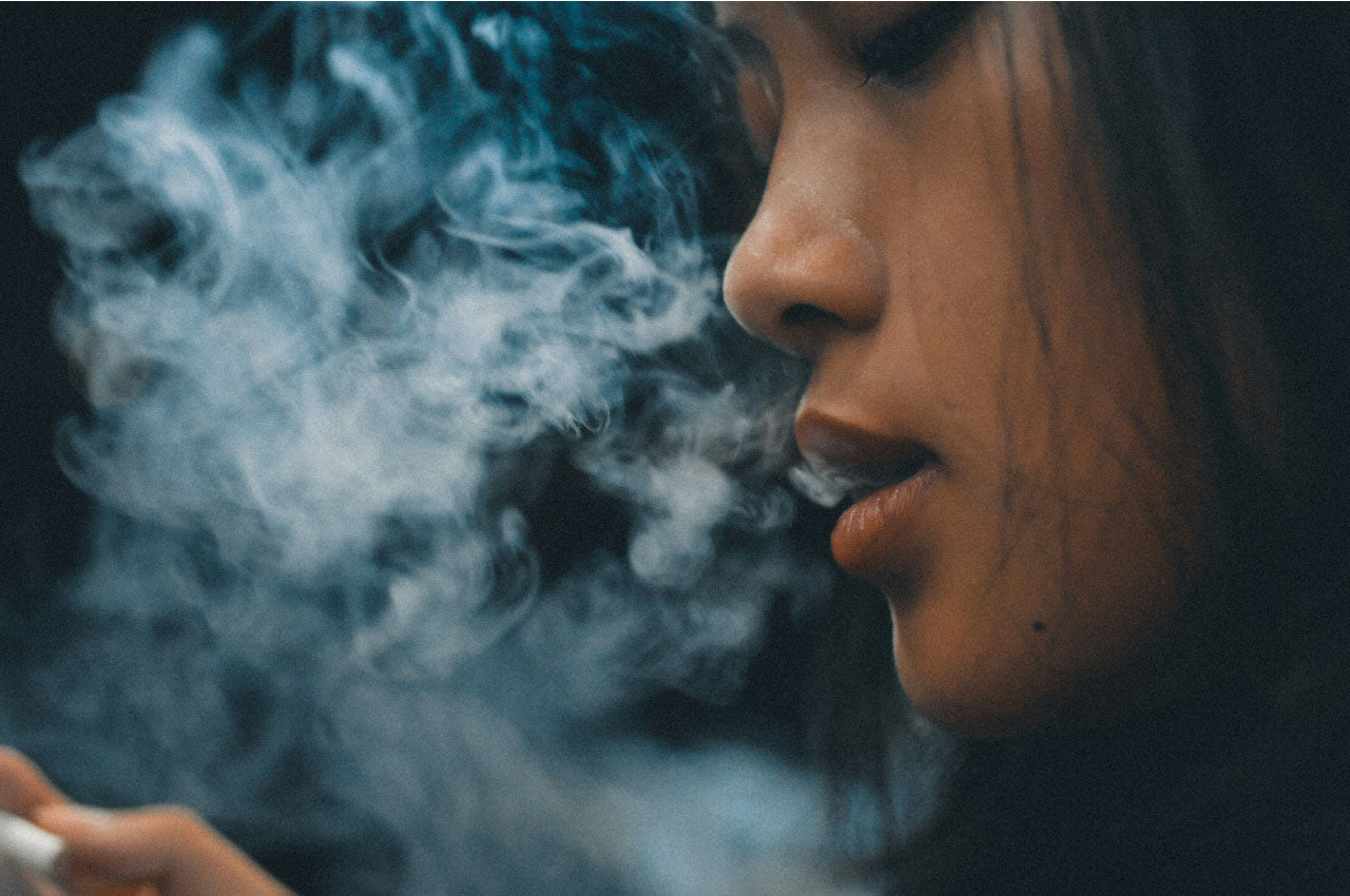 Image of a woman exhaling cannabis smoke.