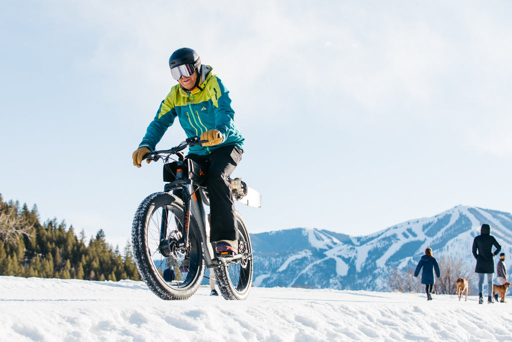 man biking PWR Dually ebike in snow with skis loaded on bike