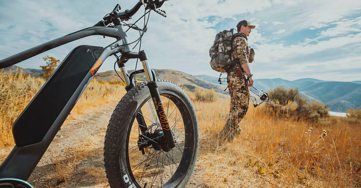 Hunter Outdoorsmen in the background PWR Dually e-bike in the foreground