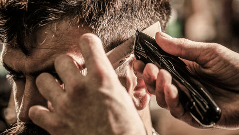 Barber using clippers and a comb