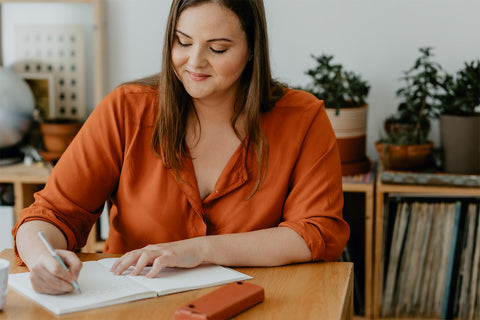 woman journaling at table