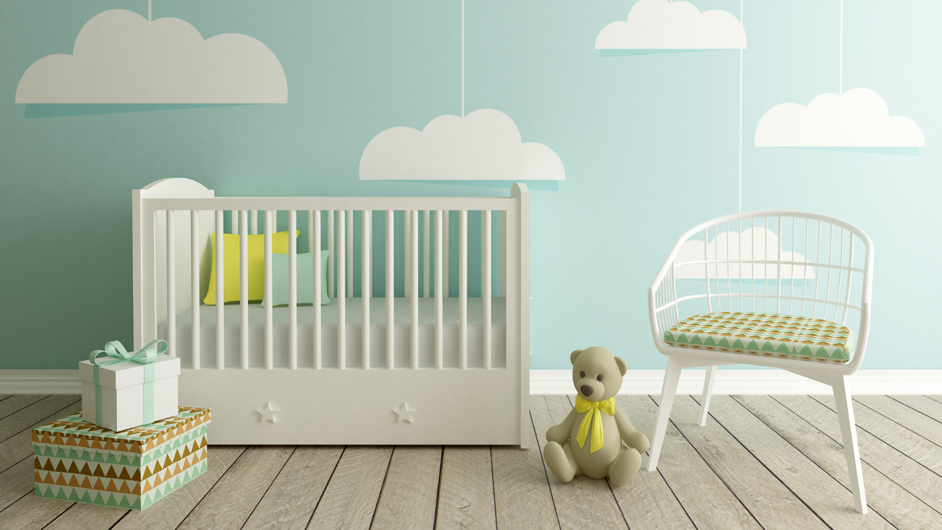 A baby nursery featuring blue walls with painted clouds, a white crib, a white chair and some baby toys/books. 