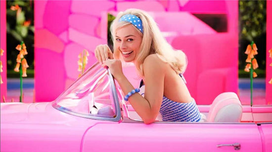 Barbie sits in her Pink car and smiles out to the audience