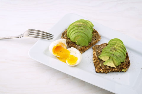 Fork and an avocado and egg breakfast dish 