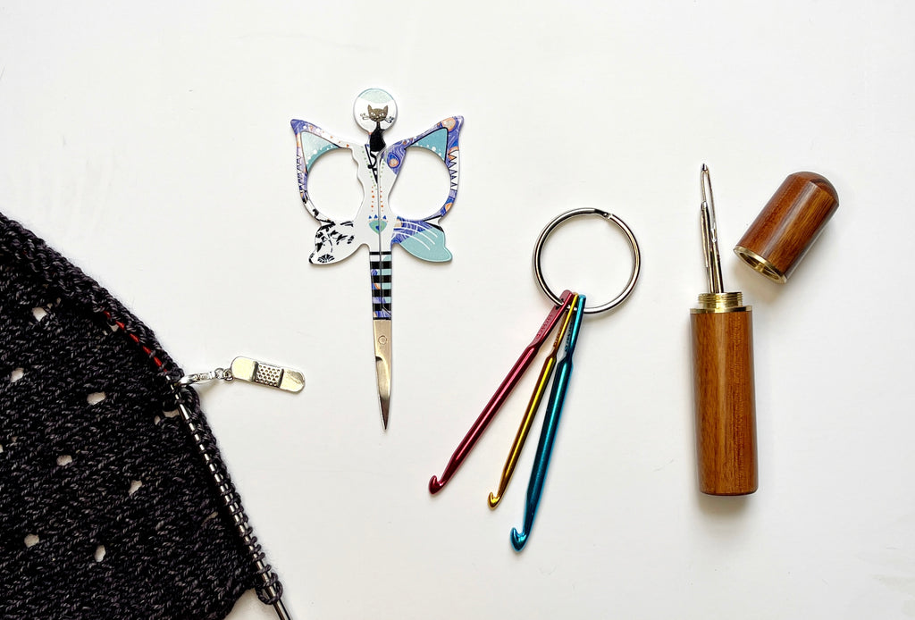 Our must have fix-it tools for knitting projects, including Fix-It Marker, knitting scissors, crochet hook, and darning needle.