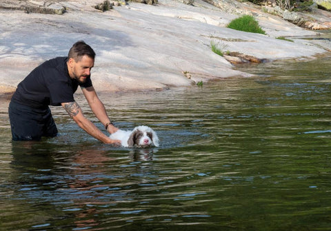 Man Teaching Puppy to Swim