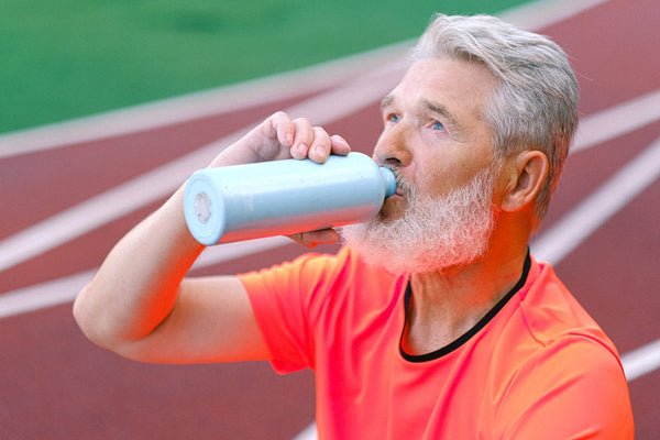 a man with a gray beard drinking water